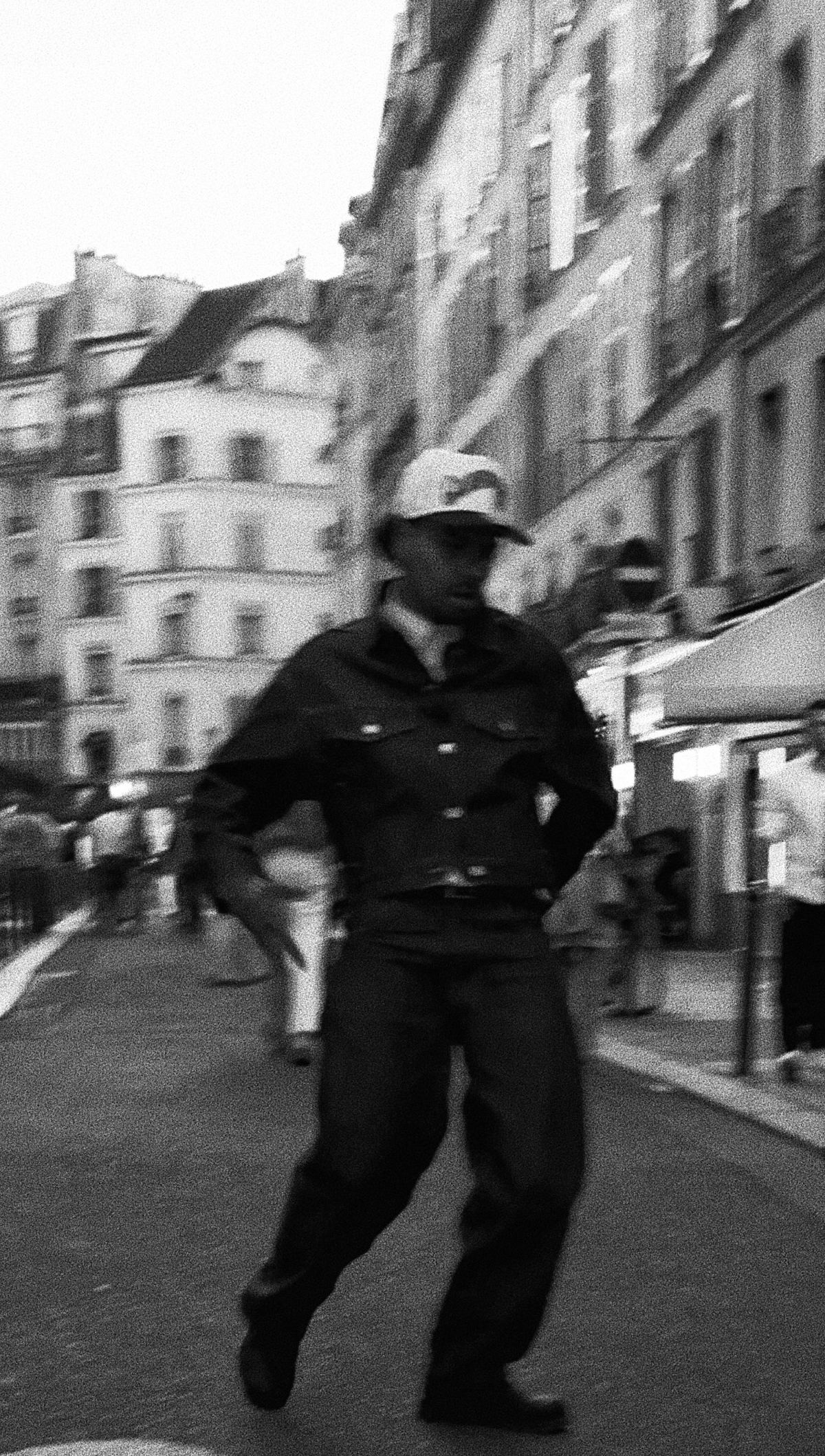 Donovan en mouvement au milieu d’une rue parisienne, photographie en noir et blanc.