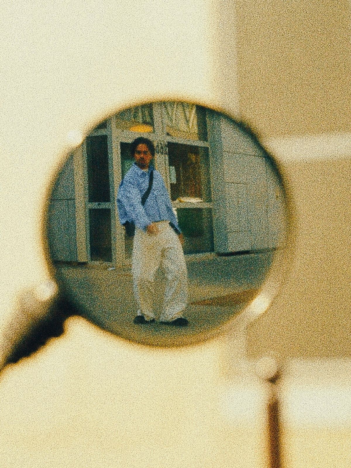 Donovan cadré à travers une loupe, image argentique très grainée.